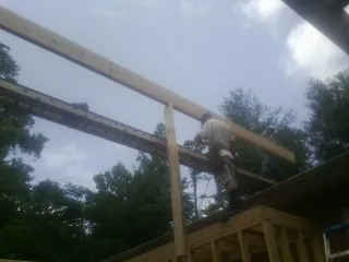 Carpenter setting a ridge beam over a new addition frame — Ice Dam Removal by Roofing Brothers in Summit Hill