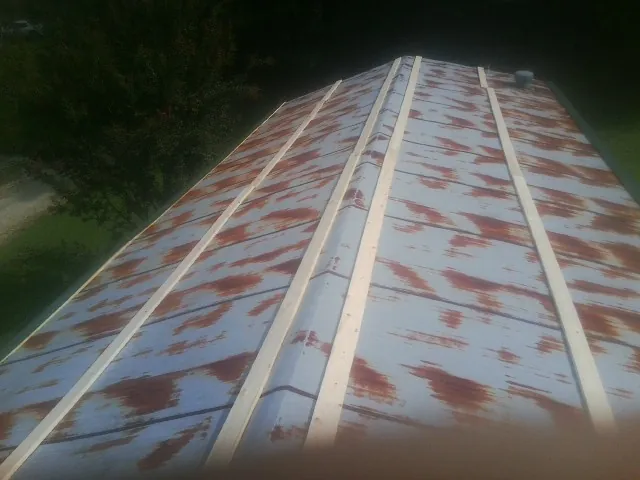 Rusted metal roof panels with new wood purlins before replacement — Storm Damage Roof Repair in Summit Hill by Roofing Brothers