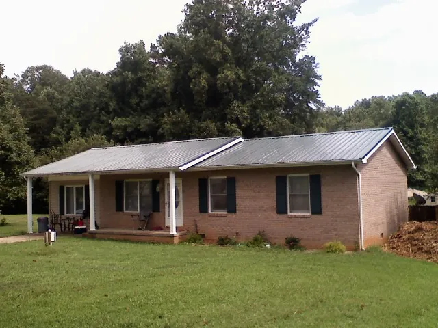 Gray metal roof on a brick ranch house with a side carport in Summit Hill