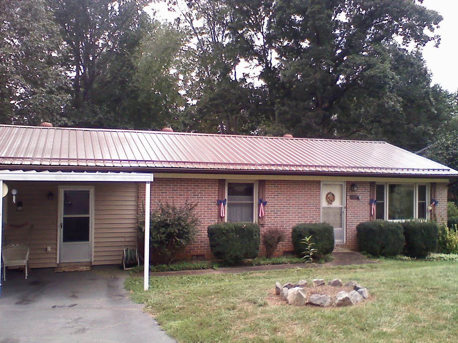 Bronze metal roof and carport on a brick ranch home — Roof Repair work by our crew in Summit Hill